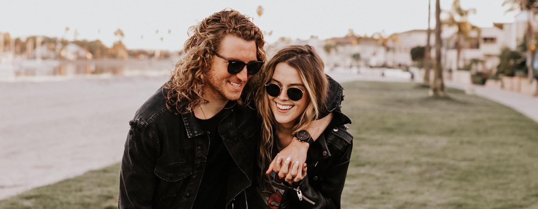 a couple walks on grassy area in open neighborhood lot